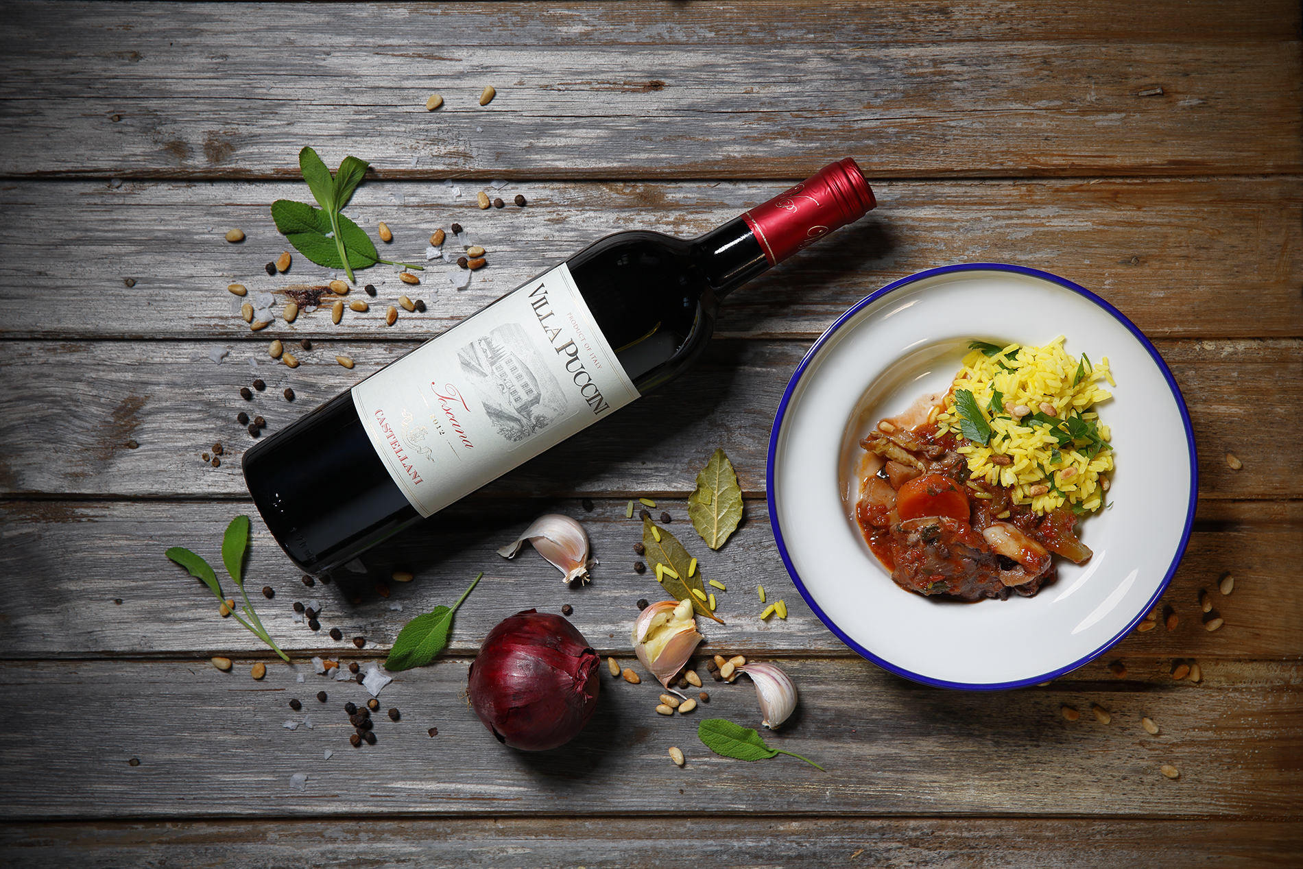 risrätt i tallrik med vinflaska och rödlök