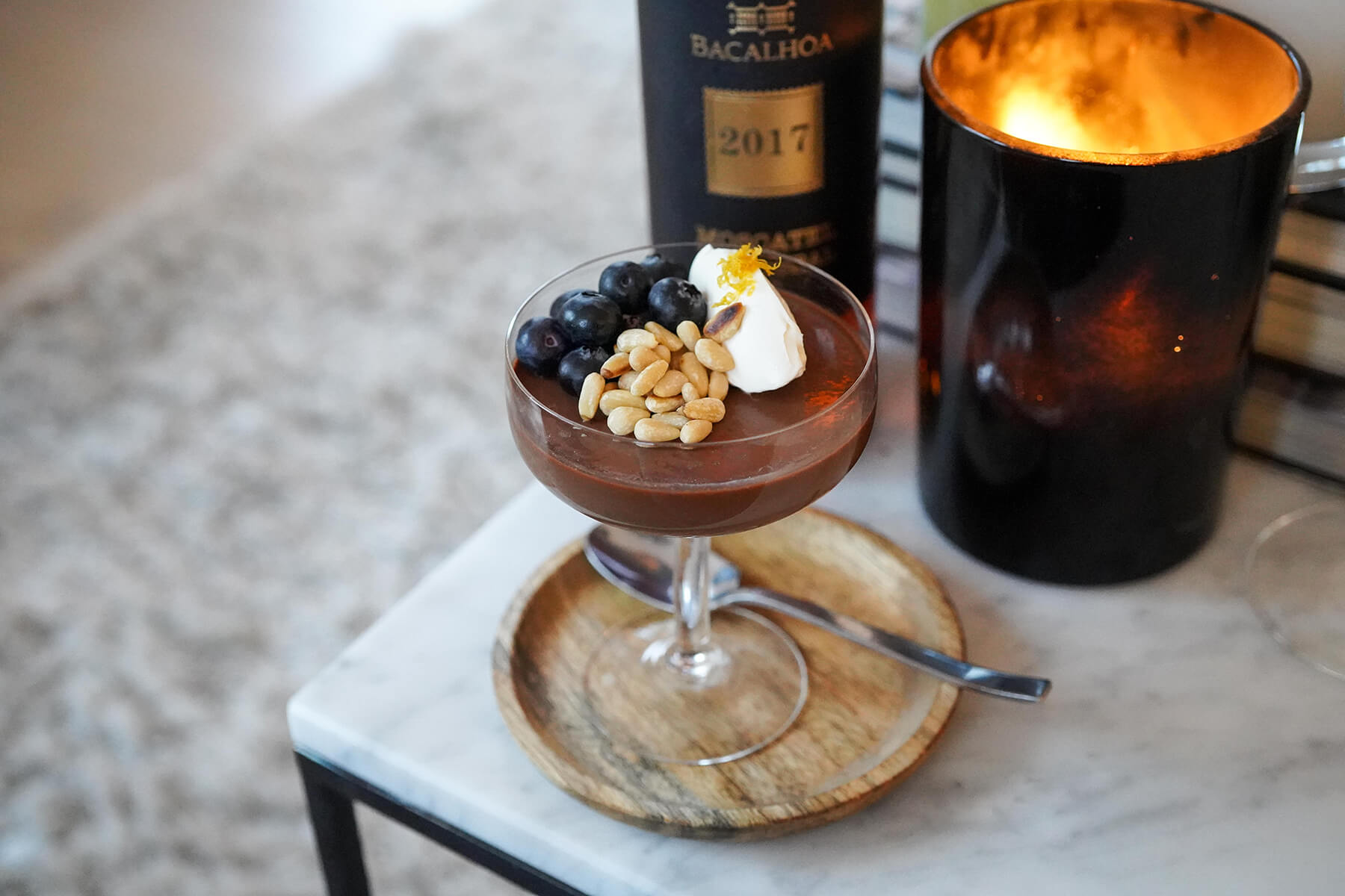 ett glas med chokladpannacotta och en flaska vin