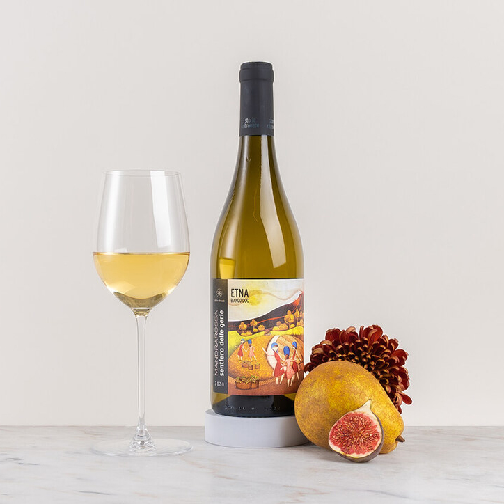 en flaska vitt vin på ett bord med blomma och frukt