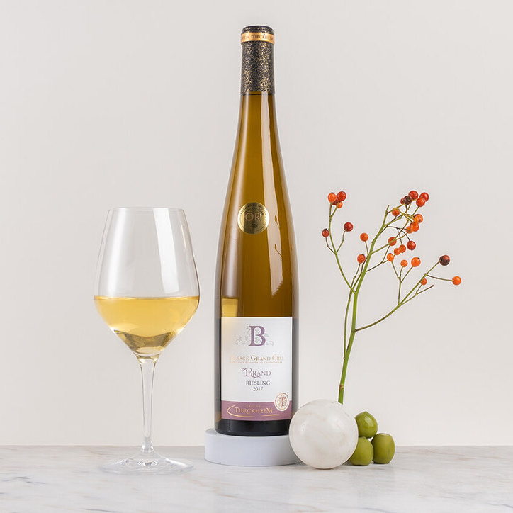 en flaska vitt vin på ett bord med blomma och frukt