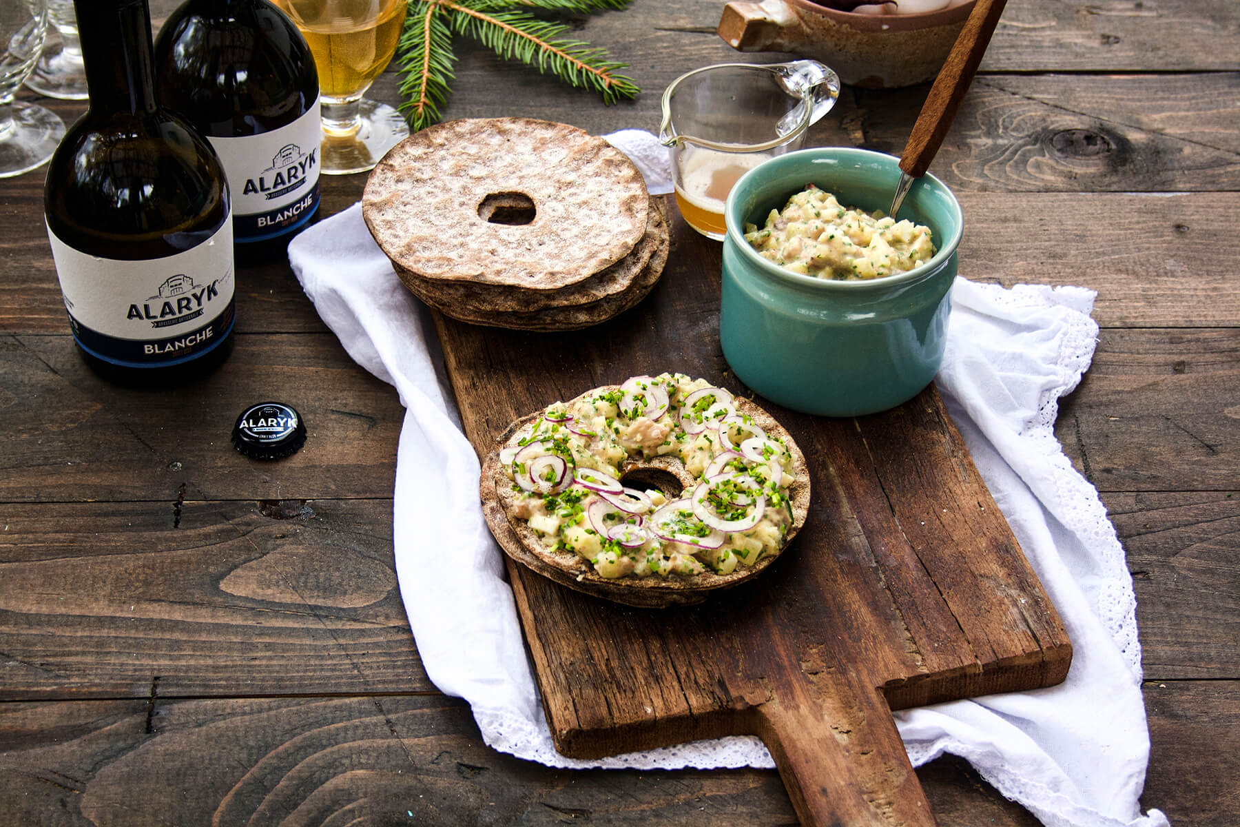 gubbröra med knäckebröd och skärbräda och ett glas med öl