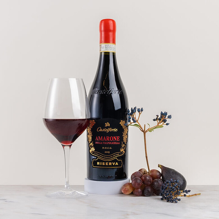 en flaska rött vin på bord med blomma och kryddor