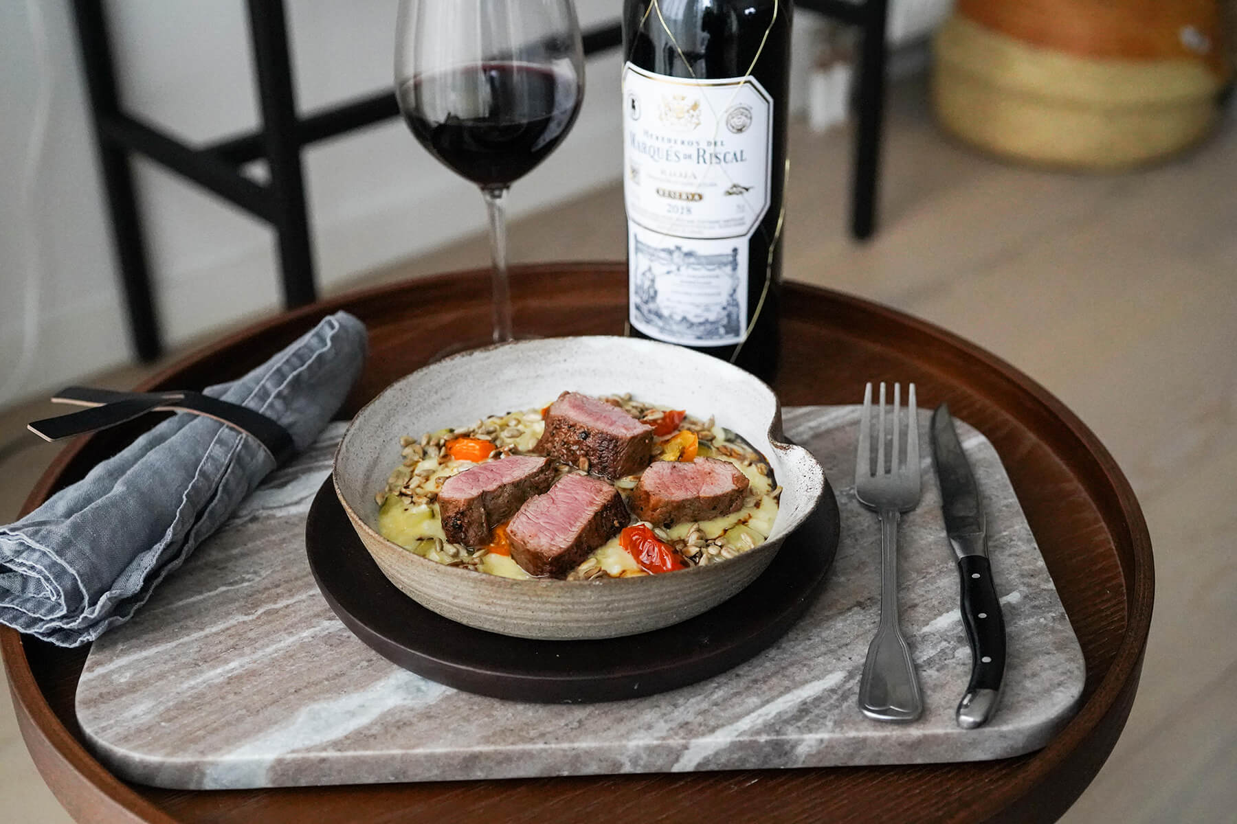 tallrik med lamm och vinflaska