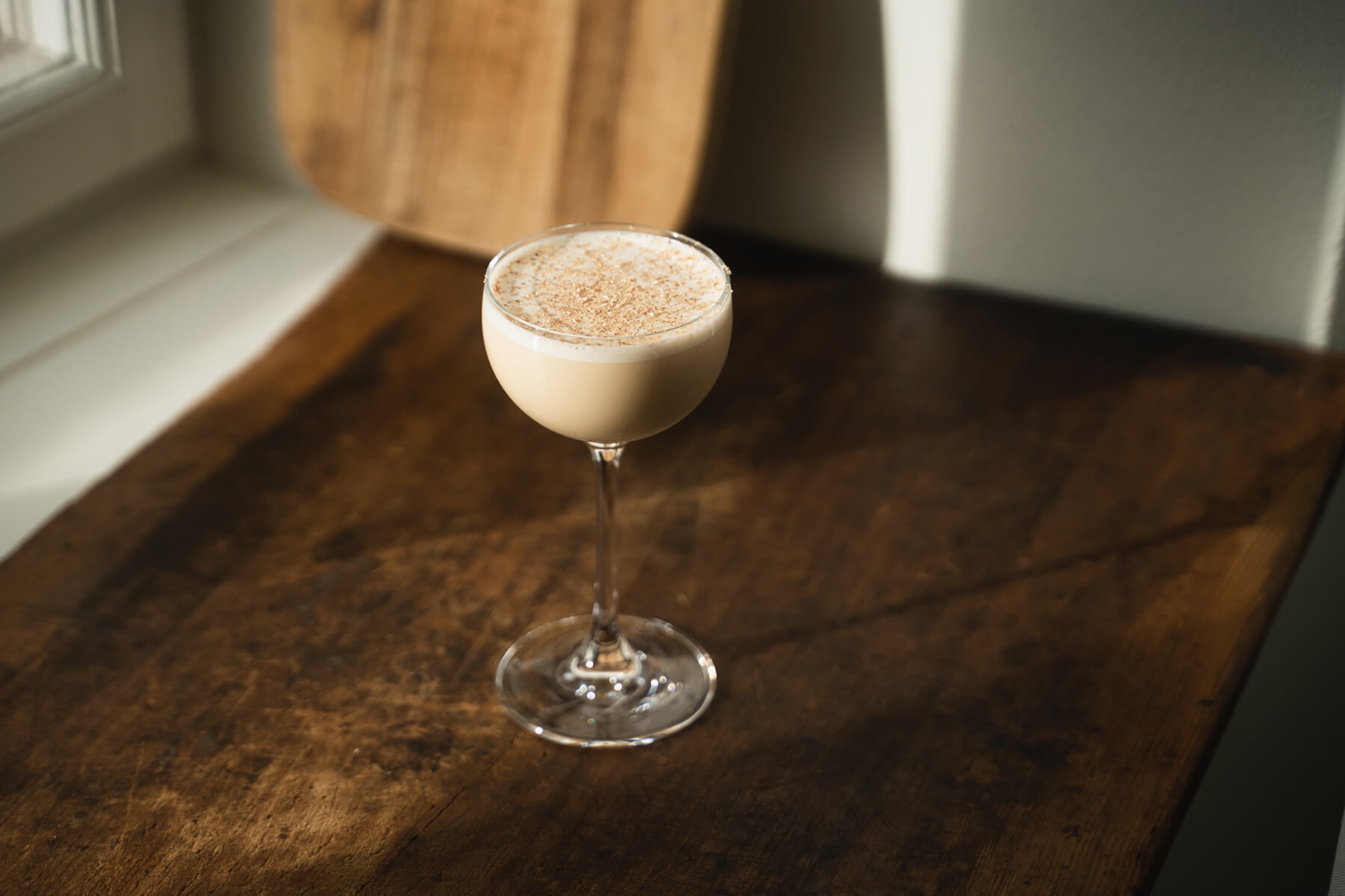 en drink äggtoddy eller eggnogg eller en drink med rom brunt bord