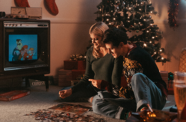 et par som lägger pussel framför tv