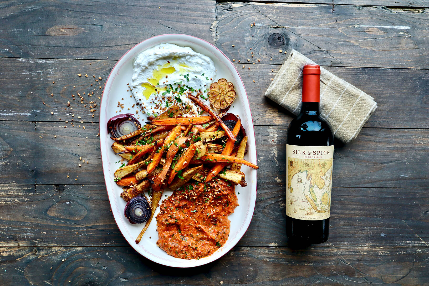 grillade rotsaker och en flaska vin på träskiva