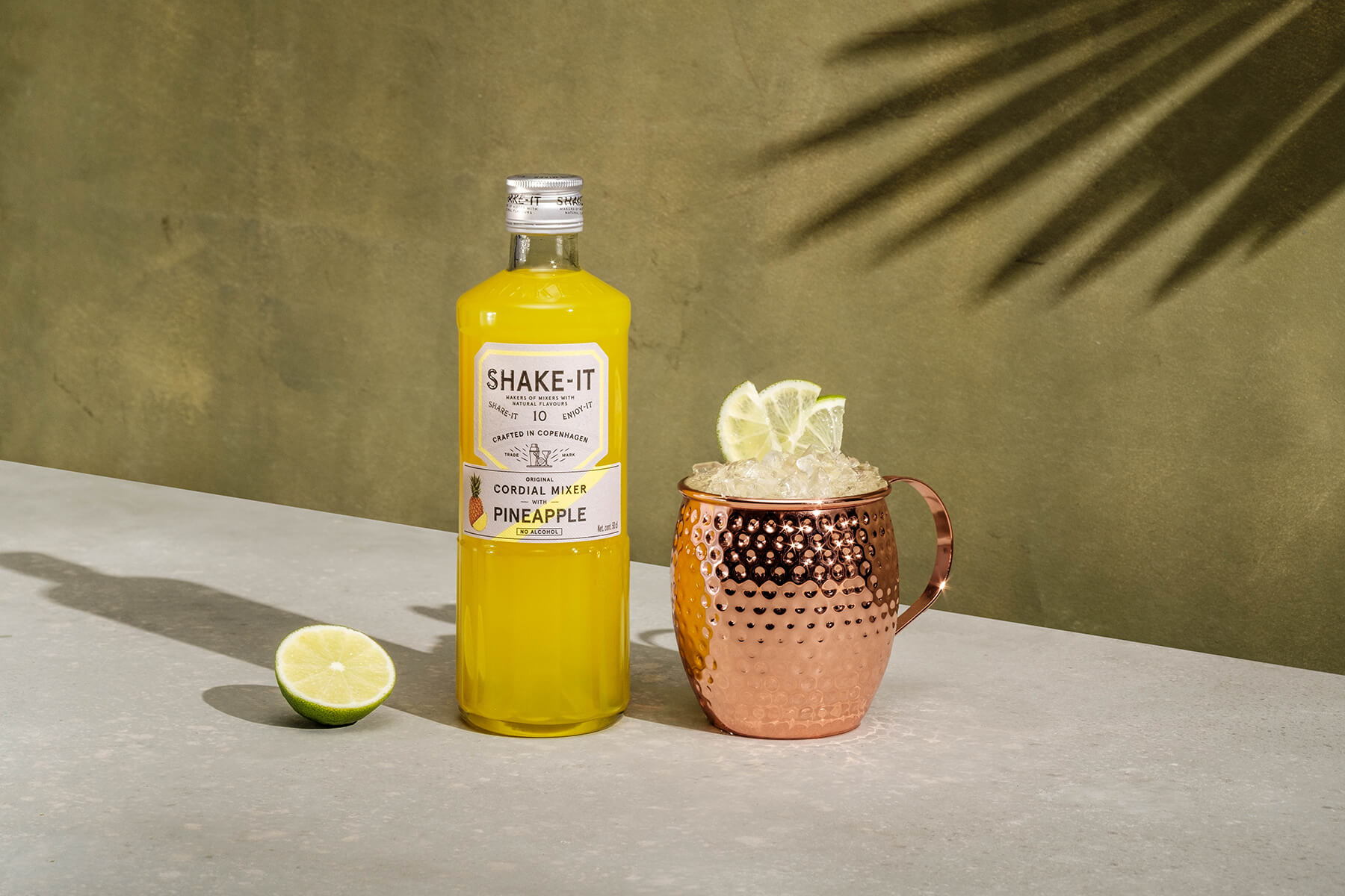 en flaska ananas dryck med en kopparkopp och drink