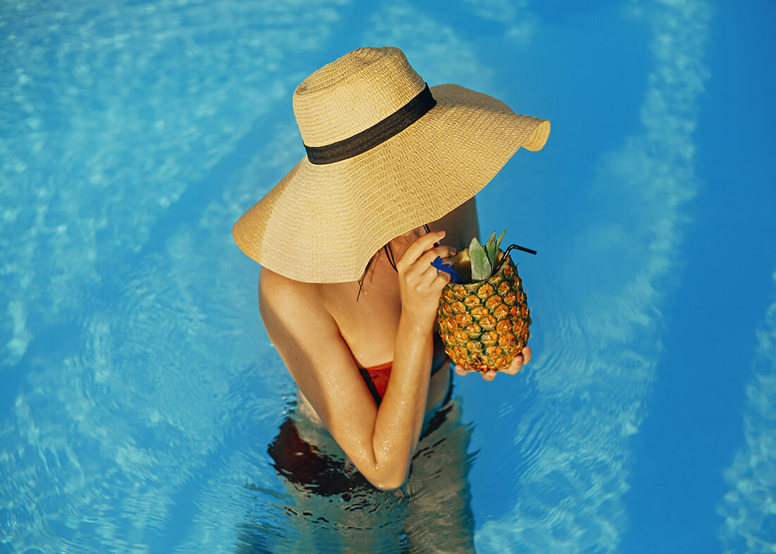 en dam i en pool som dricker en drink