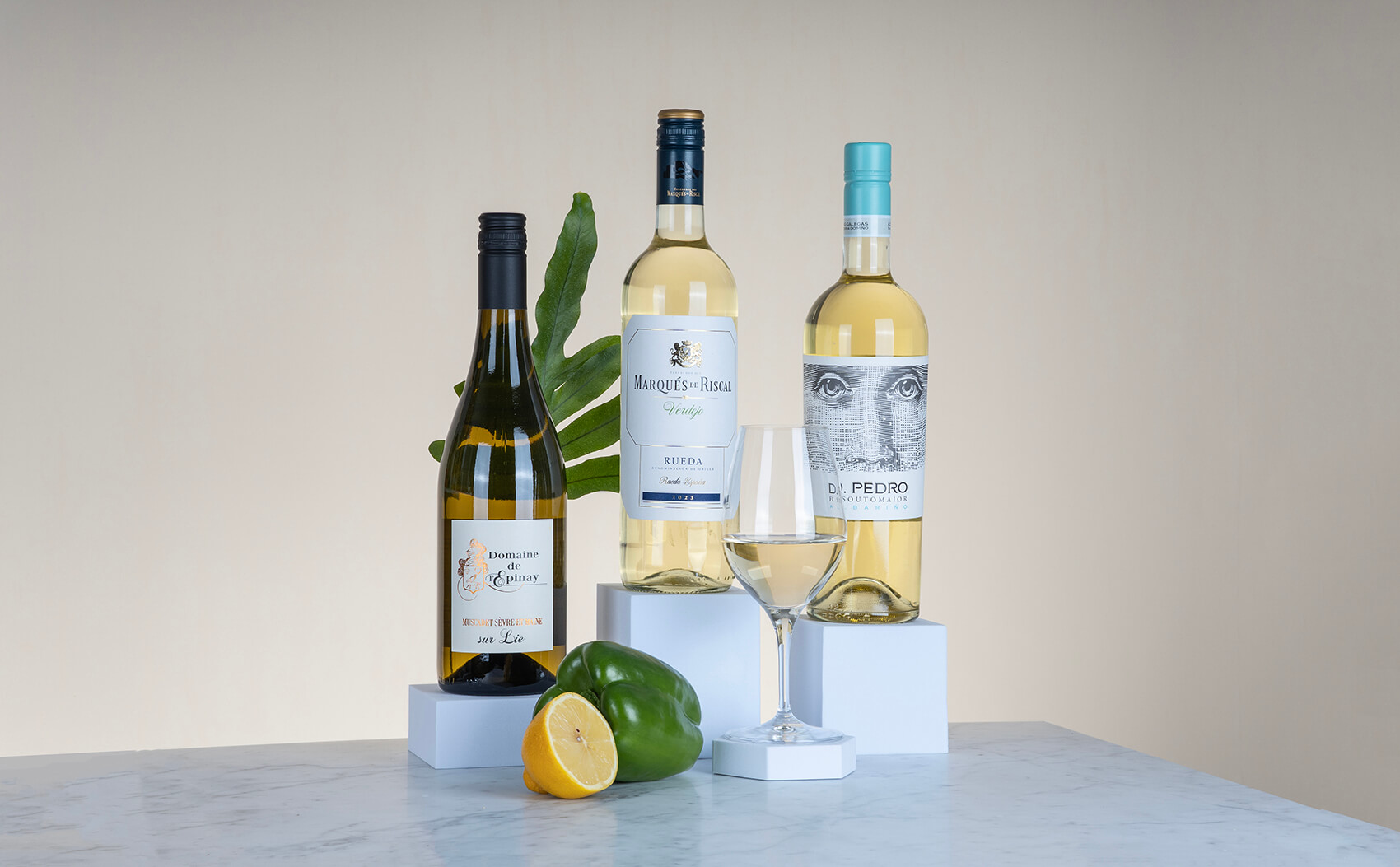 tre vita viner som står på ett beigt bakgrund