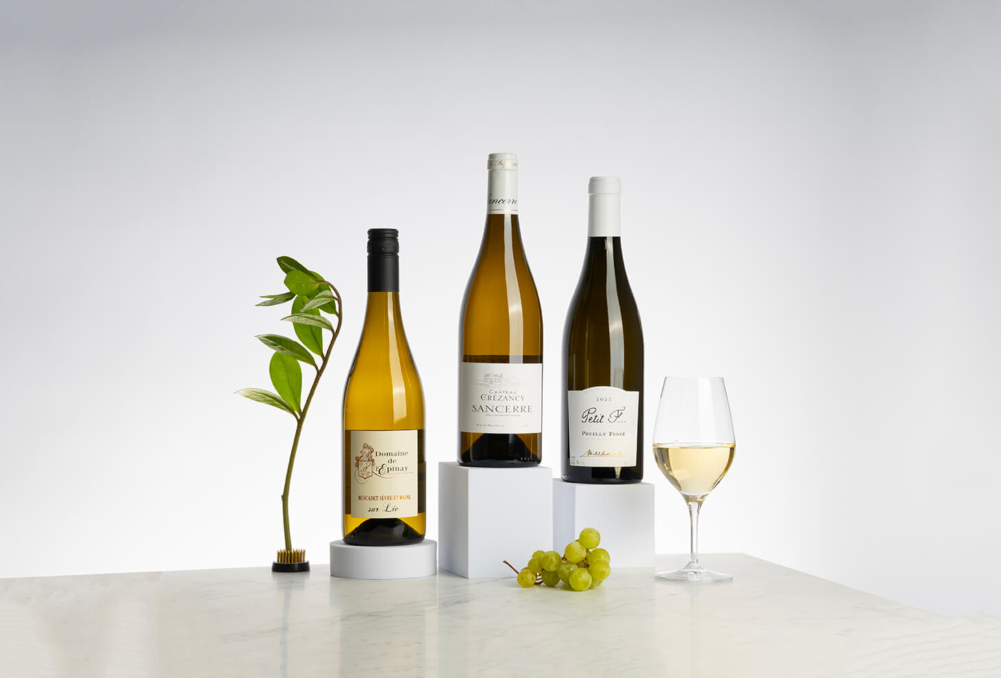 tre vita viner i gröna buteljer från loire