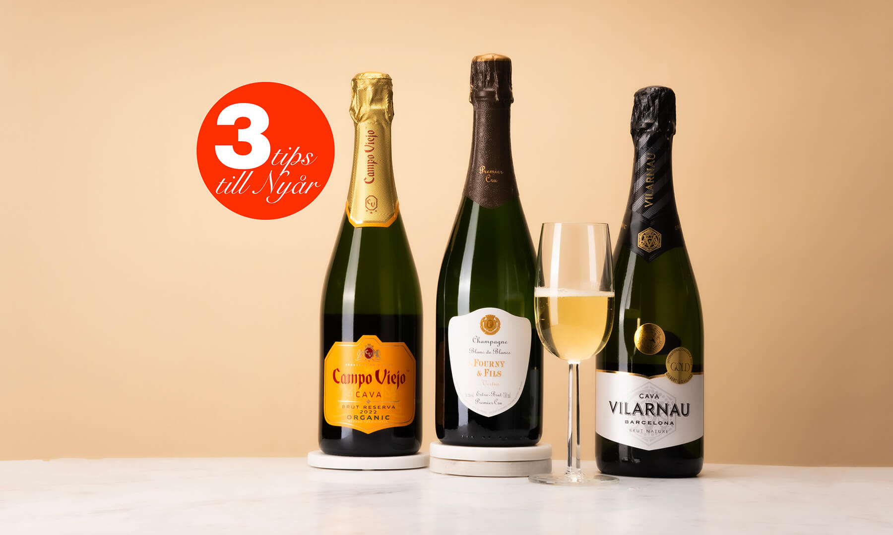 tre flaskor bubbel med ett glas mousserande vin