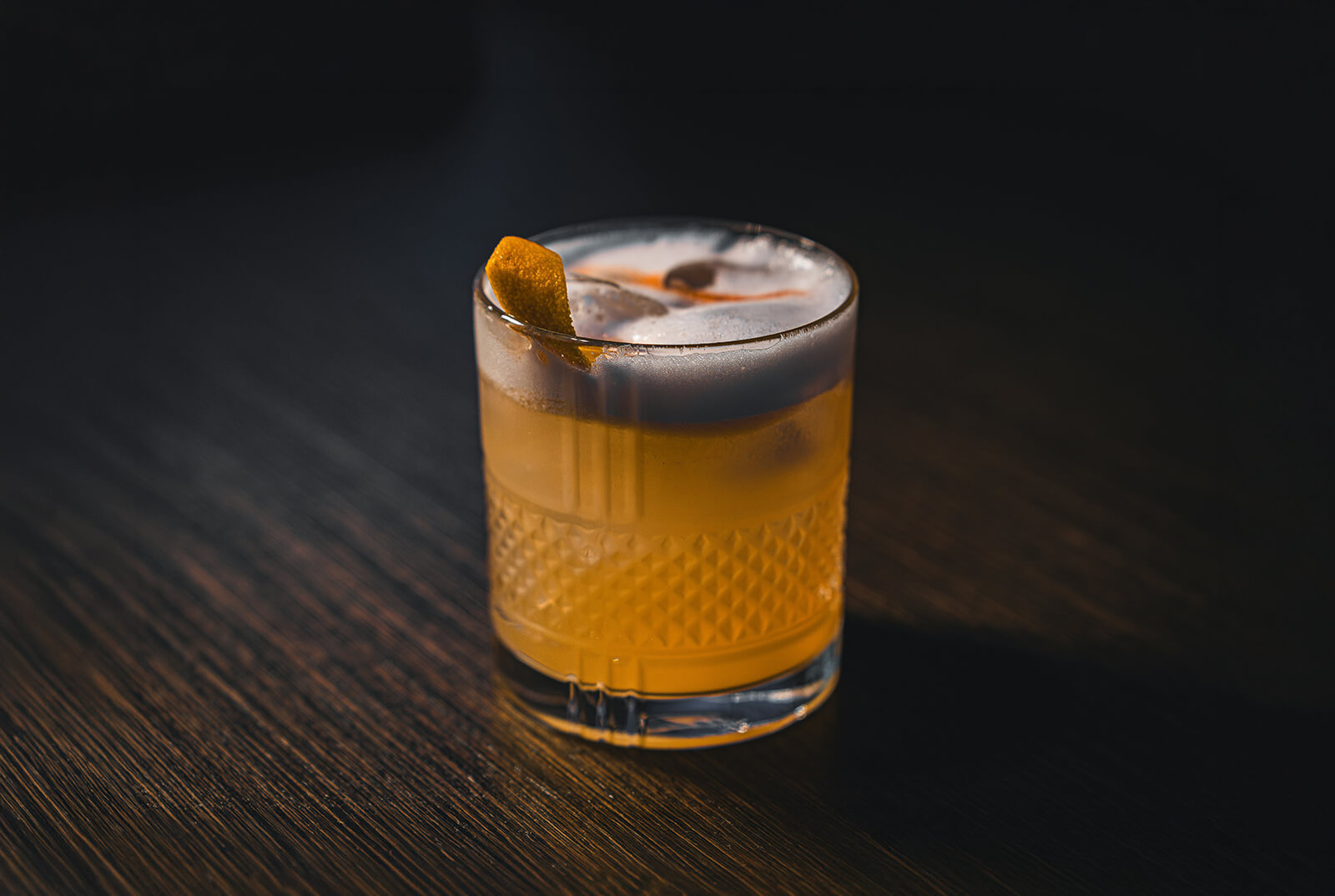 en drink I mörker whiskey sour med apelsin